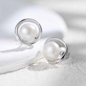 Vista macro di perle d'acqua dolce naturali su orecchini a doppio anello in argento S925