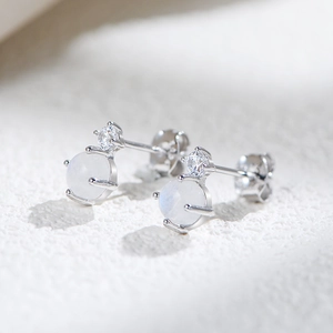 S925 silver stud earrings featuring natural moonstone and cubic zirconia on a stone surface