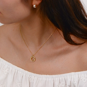 Detail of gold S925 silver double ring necklace with pavé zircons on elegant female neck