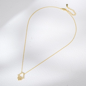Detailansicht der goldenen Hamsa-Hand mit Zirkonia-Steinen und Karabinerverschluss
