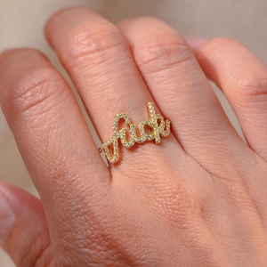 Détail d'une bague en argent s925 avec lettres en zircons micro-sertis et fini doré