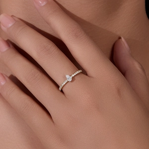 Close-up of a pear-cut zircon ring in gold finish worn on a finger for a luxury look
