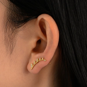 Elegant gold leaf ear climber earrings with shimmering crystals on ear lobe