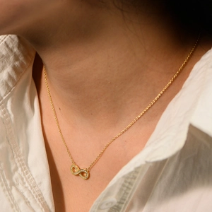 Collier infini doré avec diamants étincelants sur le cou d'un modèle pour un look chic