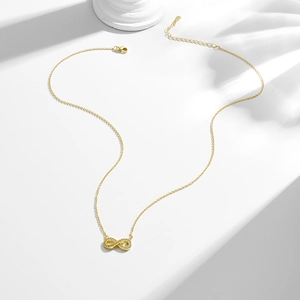 Collier infini doré avec zircons micro-paves et fermoir mousqueton sur socle minimaliste