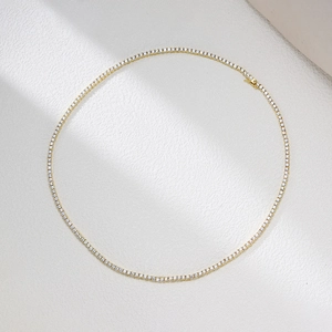 Elegante 2mm Zirkonia-Tenniskette mit 18 Karat Goldbeschichtung auf einer Steinfläche