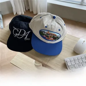 Detail of embroidered vintage baseball caps on a wooden desk with a minimalist aesthetic