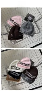 Detail of embroidered knit beanies in various colors resting in a metal shopping cart