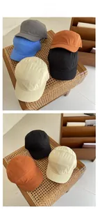 Multiple colors of five-panel cotton camp caps displayed on a woven bench