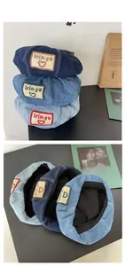 Detailed close-up showing denim fabric textures and woven logo patch on beret hats