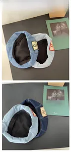 Detailed view of denim beret hats in light and dark blue with heart patch detailing