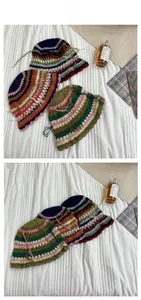 Detail of colorful hand-crocheted striped bucket hat featuring scalloped edges and tassels