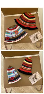 Detail of handmade crochet striped bucket hat with floral patches and XOXO embroidery