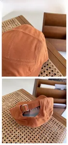 Detail of caramel canvas camper cap with premium stitching and silver metal buckle