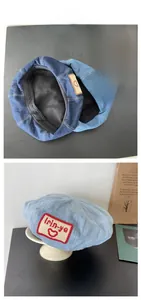 Detail of vintage denim beret caps in light and dark blue with heart patch embroidery