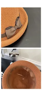 Dettaglio di un cappello da sole intrecciato marrone con fiocco e struttura interna