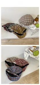 Detail of vintage plaid newsboy cap with metal buckle and woven side label fabric
