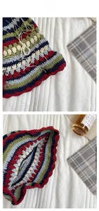 Detail of handmade crochet striped fisherman hat with colorful fringe and wavy brim