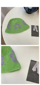 Détail du chapeau cloche en tricot vert avec motif fleur gris et texture au crochet