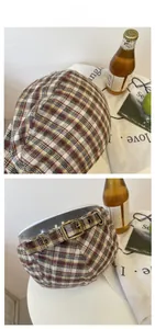 Macro detail of plaid newsboy cap with vintage metal buckle and adjustable back strap