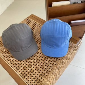 Japanese style five-panel cotton camper caps in dark grey and blue on a woven chair