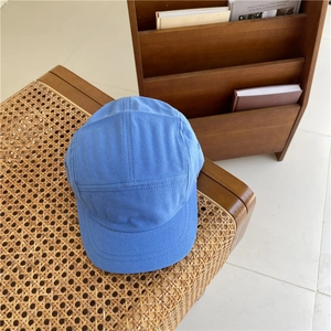 Japanese style blue 5-panel camper cap in soft suede finish on a rustic wooden background