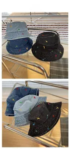 Detail display of embroidered dinosaur patterns on vintage denim bucket hats in three colors