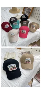 Close-up of Happy Camper embroidered patches and distressed brim on vintage baseball caps