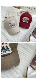 Detail showing vintage washed baseball cap with Happy Camper embroidery and distressed edges