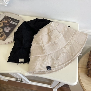 Minimalist cotton-linen bucket hats in black and beige with frayed edges and alder label