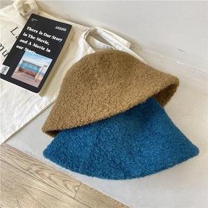 Winter lambswool bucket hats in camel and teal colors with cozy textured finish
