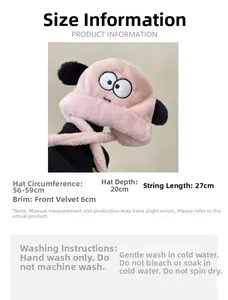 Detailed view of plush earmuff hat with cartoon eyes and washing instructions label