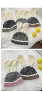 Détail du bonnet en tricot avec oreilles de lapin en peluche et rayures contrastées