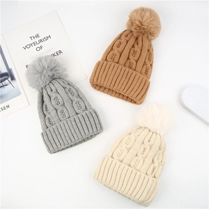 Three-piece chunky knit pom-pom hats in grey, caramel, and beige colors for winter