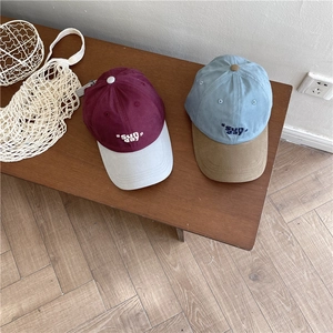 Casquettes de baseball rétro bicolores avec broderie Sun Day sur un banc en bois