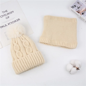 Detail of beige chunky knit beanie with faux fur pom and matching ribbed neck gaiter set