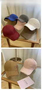 Close-up of distressed cotton baseball caps with PEACE embroidery in seven various colors