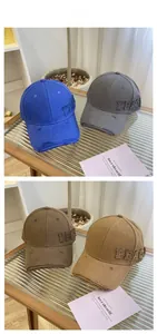 Detail of distressed baseball caps with PEACE embroidery in four retro street style colors