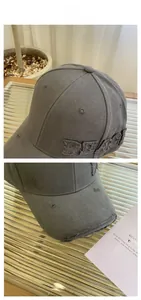 Detail of distressed dark grey cotton baseball cap with PEACE 3D embroidery and frayed edges