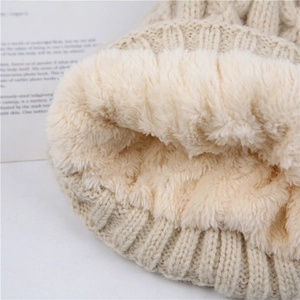 Detailed view of plush cream fleece lining inside thick cable knit winter hat