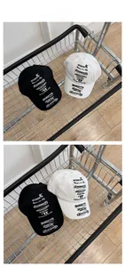 Detail of vintage style canvas baseball caps in black and white with retro font prints