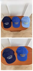 Detailed close-up of high-quality cotton baseball caps in various blue shades on a wood table