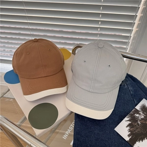 Two-tone cotton baseball caps in caramel and light gray with cream visors and soft top