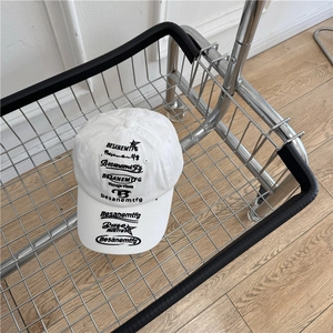 White vintage baseball cap with black graphic embroidery on metal mesh background