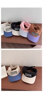 Flat lay detail showing multi-color adjustable bow-tie sun hats on wooden table