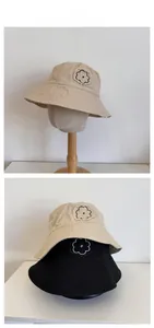 Detail of cotton canvas bucket hats with flower patch embroidery and frayed edges
