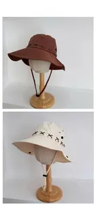 Detail of wide brim sun hats with cross-stitch design and adjustable windproof cords