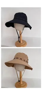 Detail view of durable canvas sun hat with brown cross stitching and adjustable chin strap