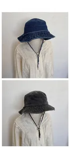 Close-up of denim bucket hats in dark blue and black with adjustable windproof drawstrings
