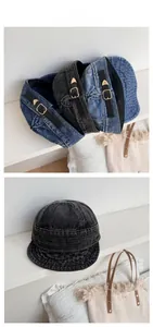 Detail of washed denim baker boy caps with leather strap adjusters and metal buckles
